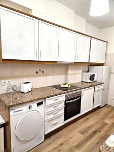 a kitchen with white cabinets and white appliances at Albufeira Old Town T3 with Balcony in Albufeira