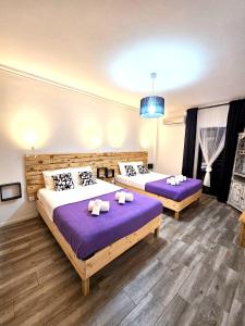 two beds in a room with purple sheets at Albufeira Old Town T3 with Balcony in Albufeira