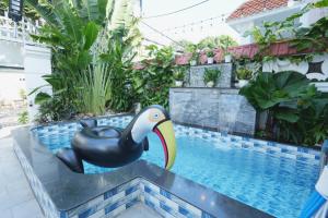 a statue of a pelican sitting on the edge of a swimming pool at Villages ĐĂNG KHOA Trung Tâm CỘT CỜ in Vung Tau