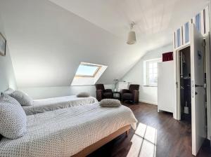 ein weißes Zimmer mit 2 Betten und einem Tisch in der Unterkunft La Cour de Grandmenil in Manhay
