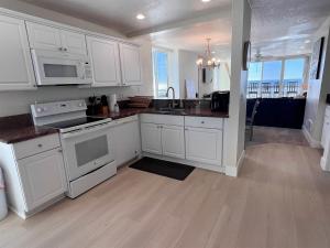 een keuken met witte kasten en een aanrecht bij D24 - Cottage on the Sand in Oceanside