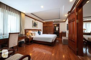 a hotel room with a bed and a desk and a room at Thien Thai Hotel & Spa in Hanoi