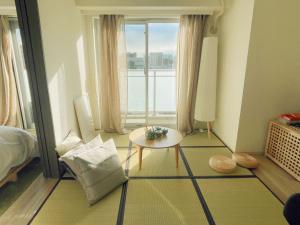 a room with a bed and a table and a window at Nippori Bristol Hotel in Tokyo