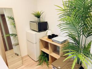a room with a refrigerator and a tv on a table at Nippori Bristol Hotel in Tokyo