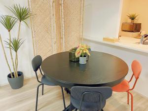 a black table and chairs in a room with plants at Nippori Bristol Hotel in Tokyo