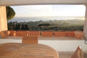 einen Holztisch und Stühle auf einem Balkon mit Aussicht in der Unterkunft Appartamento Sabatinus in Trevignano Romano