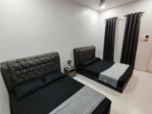 um quarto com 2 camas e um sofá em Roomstay Kak Ton em Kuala Terengganu