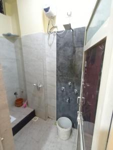 een badkamer met een douche en een toilet bij Anand Yatri Grah, Ujjain in Ujjain