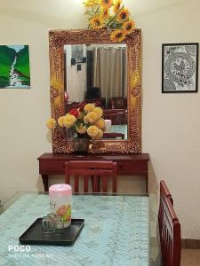 a mirror sitting on top of a table in front of a table with flowers at Lake View Cottage Wayanad in Tariyod