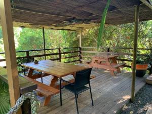 a wooden deck with a picnic table and a bench at Le Nirvana - Oasis de Tendéa - Farino in Farino