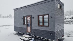 een tiny house wordt getoond in de sneeuw bij Tiny House Flexhome in Buchenberg