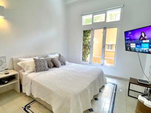 - une chambre avec un lit et une télévision à écran plat dans l'établissement Apartment in the Old City with balcony and swimming pool, à Carthagène des Indes
