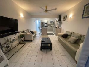 a living room with a couch and a flat screen tv at 23 Residence Thalassa, in Belle Mare