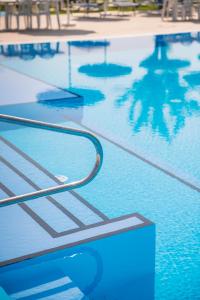 una piscina con ringhiera di metallo in acqua di Hotel Baya - in centro, sul mare a Milano Marittima