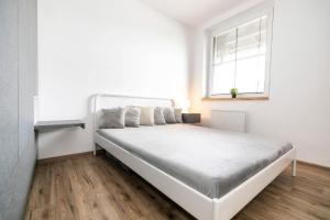 a white bed in a room with a window at Apartmán 17 priamo na svahu so zľavou na skipasy in Donovaly