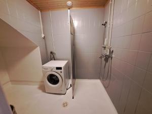 y baño con lavadora y ducha. en Huoneisto Neristan Kokkola, en Kokkola