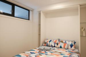 CBD Japanese Retreat 2BR 1P Brekky Wifi Netflix في كانبرا: غرفة نوم بسرير ونافذة