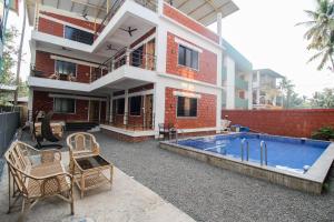 a house with a swimming pool in front of it at Redstone Resort-Nagaon-Alibaug in Nagaon