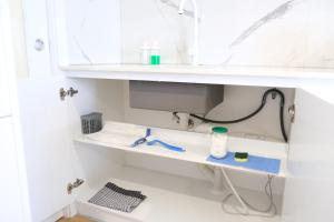 堪培拉CBD Japanese Retreat 2BR 1P Brekky Wifi Netflix的浴室设有白色的架子和水槽 更多33张照片