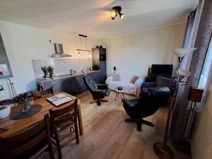 a kitchen and living room with a table and chairs at DE BLOEMENTUIN / A VIRÁGOSKERT in Tiszafüred
