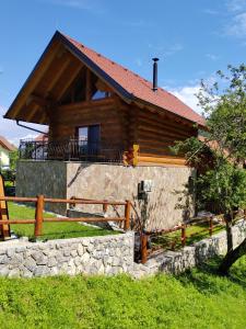 una cabaña de madera con una valla delante en Brunarica Biopark -Log house Biopark en Grosuplje