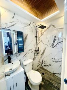 ein Badezimmer mit einem weißen WC und einem Waschbecken in der Unterkunft Modern House in Butuan City with 2bedrooms in Camella in Butuan