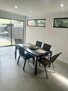 uma sala de jantar com uma mesa preta e cadeiras em Townhouse in West Footscray em Seddon