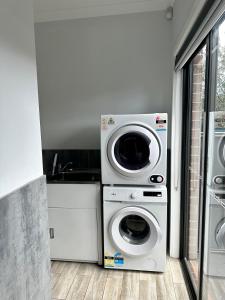 uma cozinha com uma máquina de lavar roupa e uma máquina de lavar roupa em Townhouse in West Footscray em Seddon