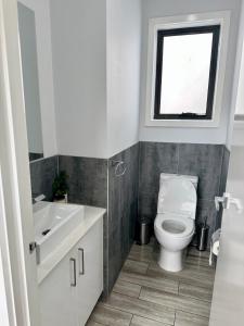 a bathroom with a toilet and a sink and a window at Townhouse in West Footscray in Seddon