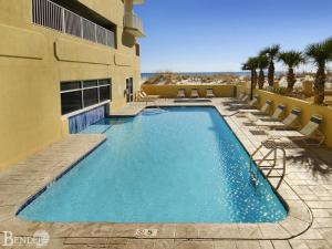 a swimming pool with chairs and a building at Island Royale P102 in Gulf Shores