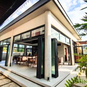 a house with glass doors and a dining area at Mula De La Paz in Zambales