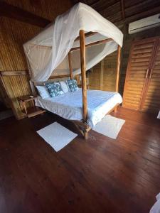 a bed with a canopy in a room at Cheerful 3-bedroom holiday beach cabin. in Inhambane