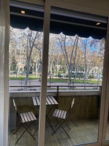 Duas cadeiras numa varanda com vista para um parque em Lujoso apto Paseo Del Prado em Madrid