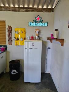 a kitchen with a refrigerator and a sign on the wall at Santa Filomena Camping in Descalvado
