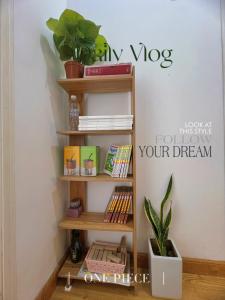 a book shelf with books and a plant at Lavie House in Da Lat
