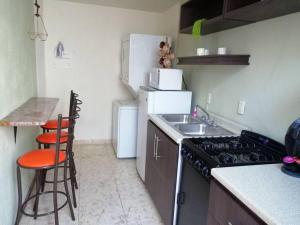 a small kitchen with a stove and a sink at New house in historic center, close to amenities. in Zacatecas