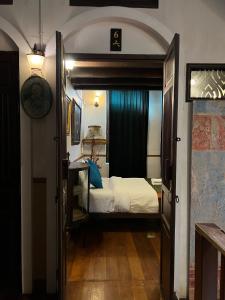 a bedroom with a bed and an open door at 103 - Bed and Brews in Bangkok