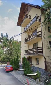 a building with a red car parked in front of it at Chic MiniSuite Mirage Sinaia in Sinaia