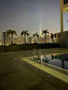 una piscina con un perfil urbano de fondo en UTM Hotel & Residence en Kuala Lumpur