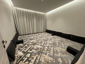 una sala d'attesa con divano e tappeto di شاليه الرتاج الفندقي a Buraydah