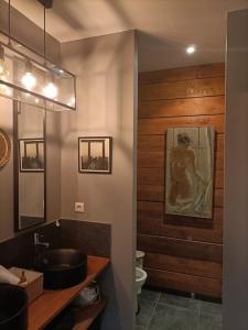 een badkamer met een wastafel en een schilderij aan de muur bij Le loft de Vincennes in Vincennes