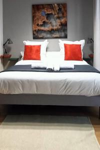 een slaapkamer met een groot bed met rode kussens bij Le loft de Vincennes in Vincennes