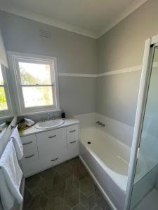 ein Badezimmer mit Badewanne, Waschbecken und Dusche in der Unterkunft Cottage 32 in Lakes Entrance
