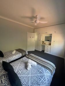 a bedroom with a bed with a white cat laying on it at Cottage 32 in Lakes Entrance