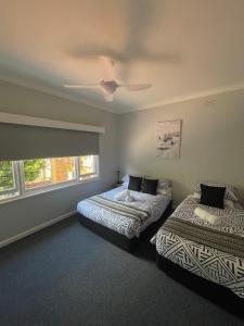 ein Schlafzimmer mit zwei Betten und einem Deckenventilator in der Unterkunft Cottage 32 in Lakes Entrance