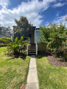 a house with a pathway leading to a yard at Cottage 32 in Lakes Entrance