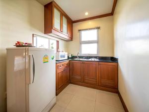 曼谷的住宿－Nana Studio Suite，厨房配有白色冰箱和木制橱柜。