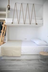 um quarto com uma cama com lençóis brancos e uma escada em White Nadora Naxos Villa em Agia Anna (Naxos)