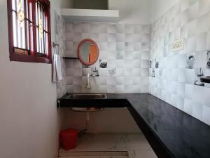 a bathroom with a sink and a mirror at Rudra Villas in Rāmeswaram