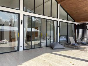 a house with large glass doors and a bedroom at Роскошная вилла Lolux Villas in Srithanu